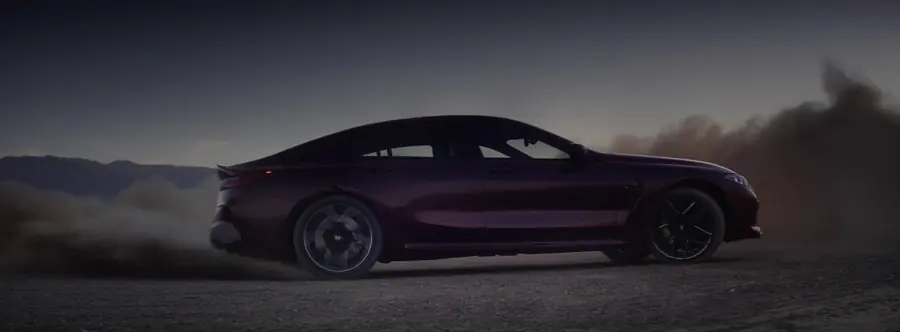 M8 drifting on a dirt road at dawn, dust behind